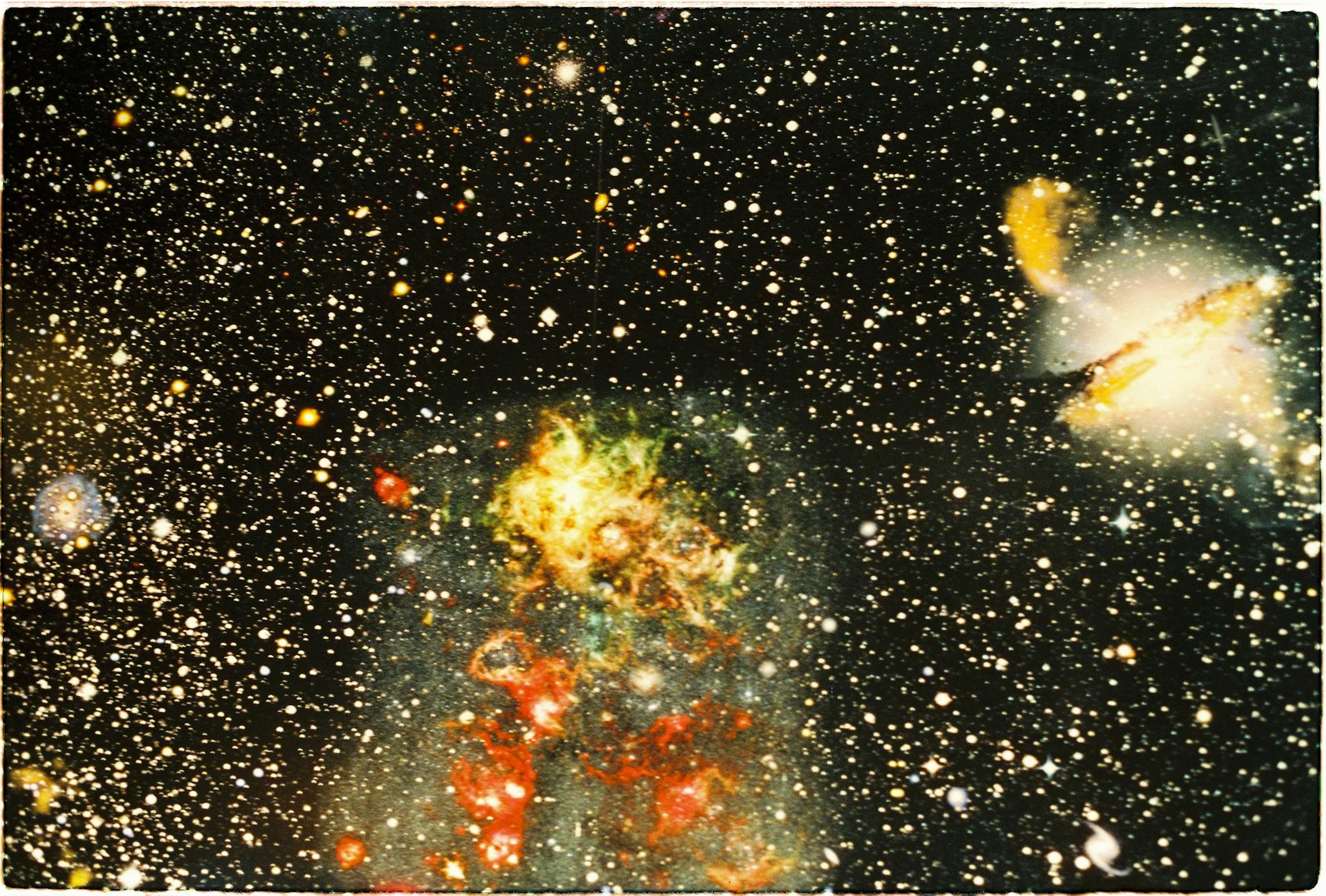 Colorful nebula and distant galaxy captured in a star-filled cosmic scene.