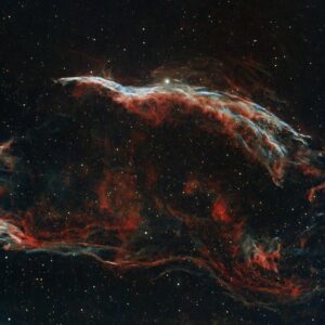 Explore the vibrant colors and patterns of the Veil Nebula captured in deep space.